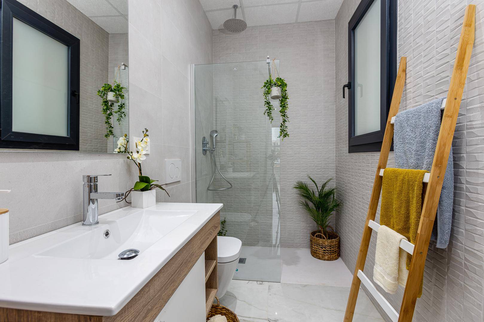 Modernes Badezimmer mit begehbarer Dusche, Regenbrause, Einzelwaschbecken und Fenster.