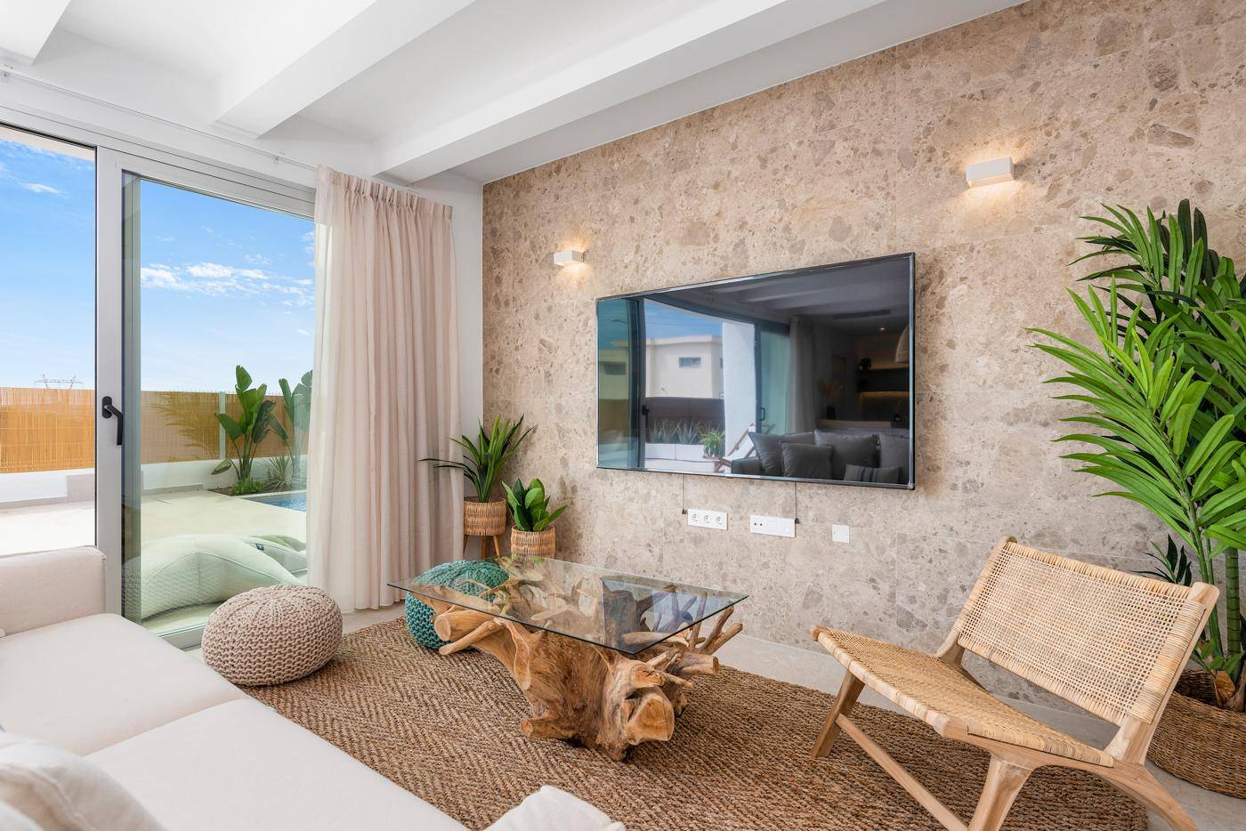 Gemütliches Wohnzimmer mit Steinfassade, modernem TV und Terrassenzugang.