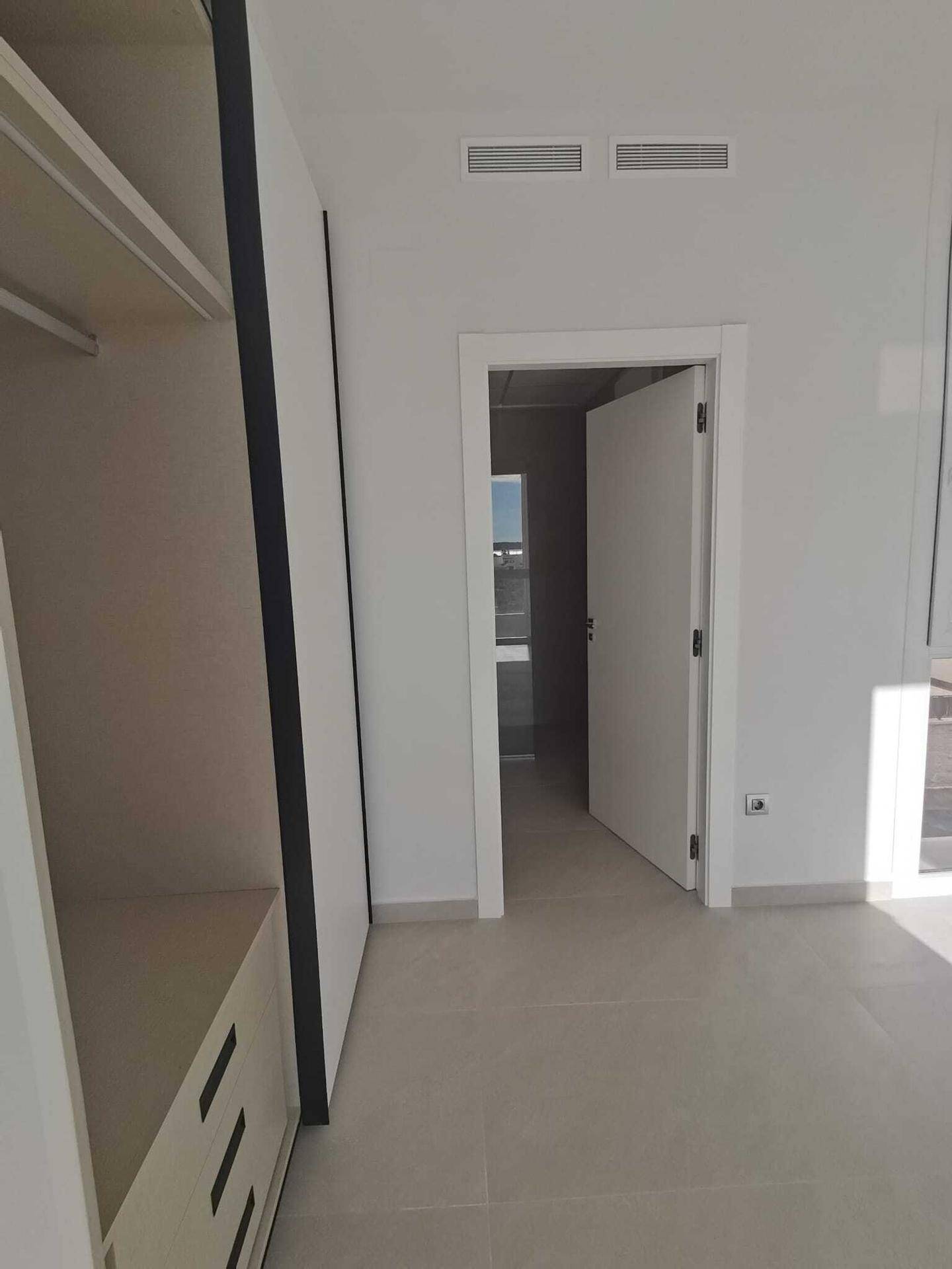 Helles Schlafzimmer mit Einbauschrank und Blick auf den Außenbereich, bereit zur Einrichtung.
