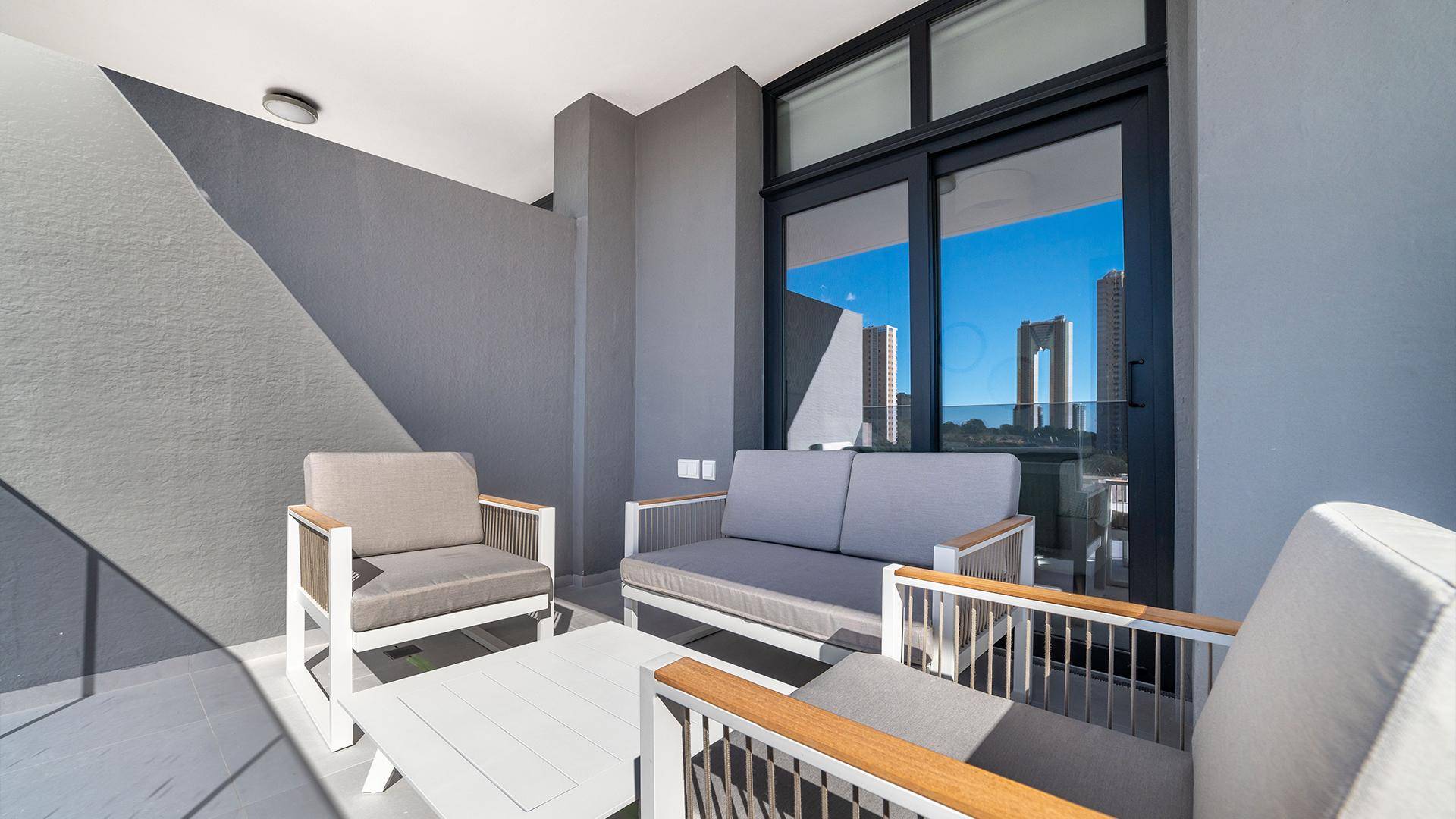 Gemütlicher Balkon mit modernen Sitzmöbeln und Blick auf die Stadt.