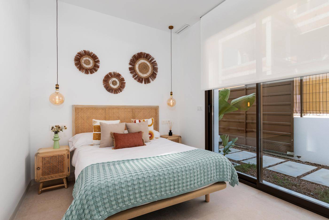 Gemütliches Schlafzimmer mit großen Schiebetüren zum privaten Innenhof und moderner Einrichtung.