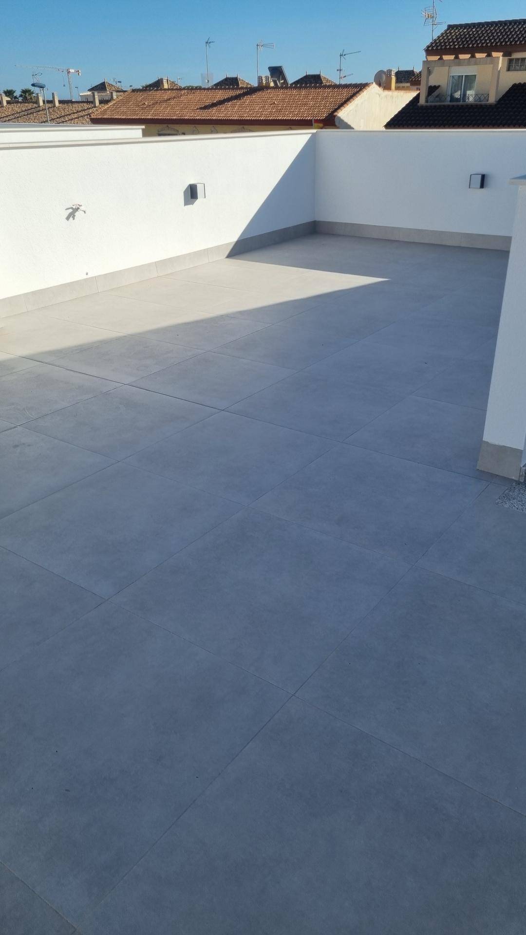 Geräumige Dachterrasse mit Fliesenboden und weitem Blick über die Umgebung.