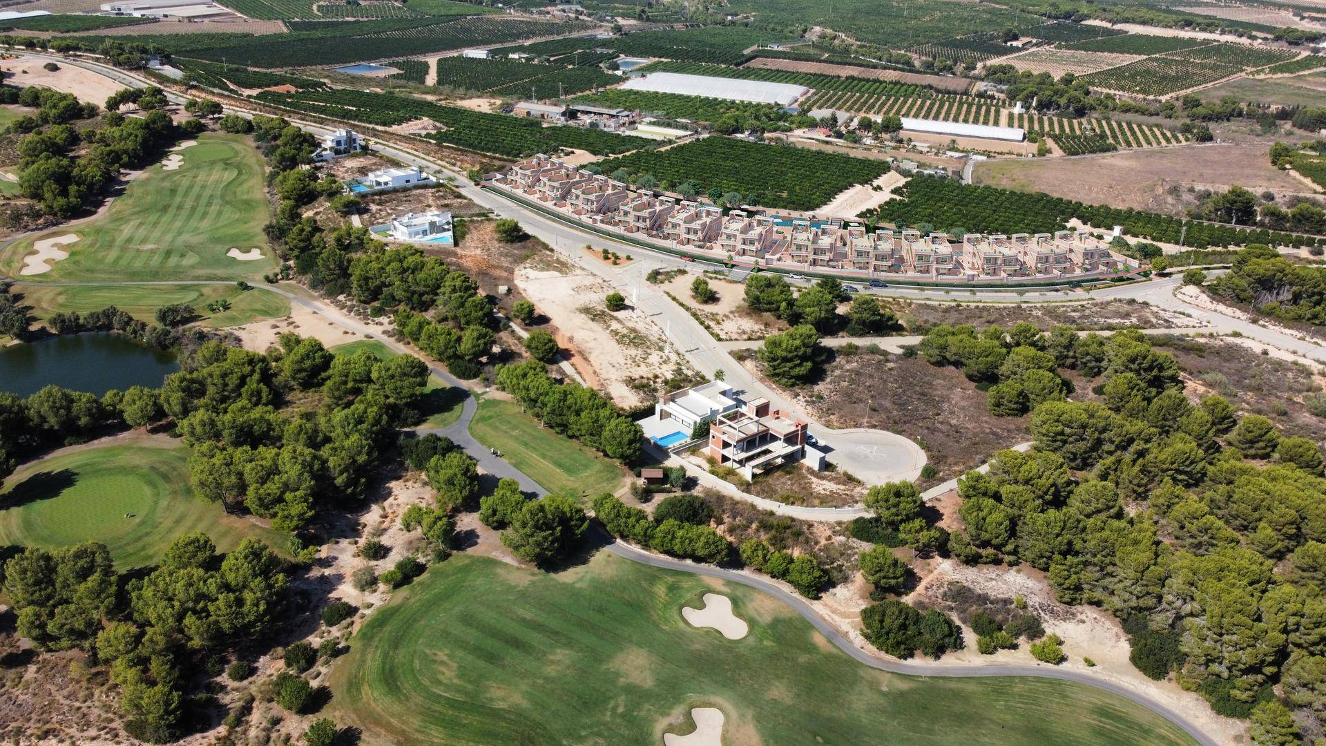 Luftaufnahme der Wohnanlage inmitten einer weitläufigen Golfplatz- und Naturlandschaft.