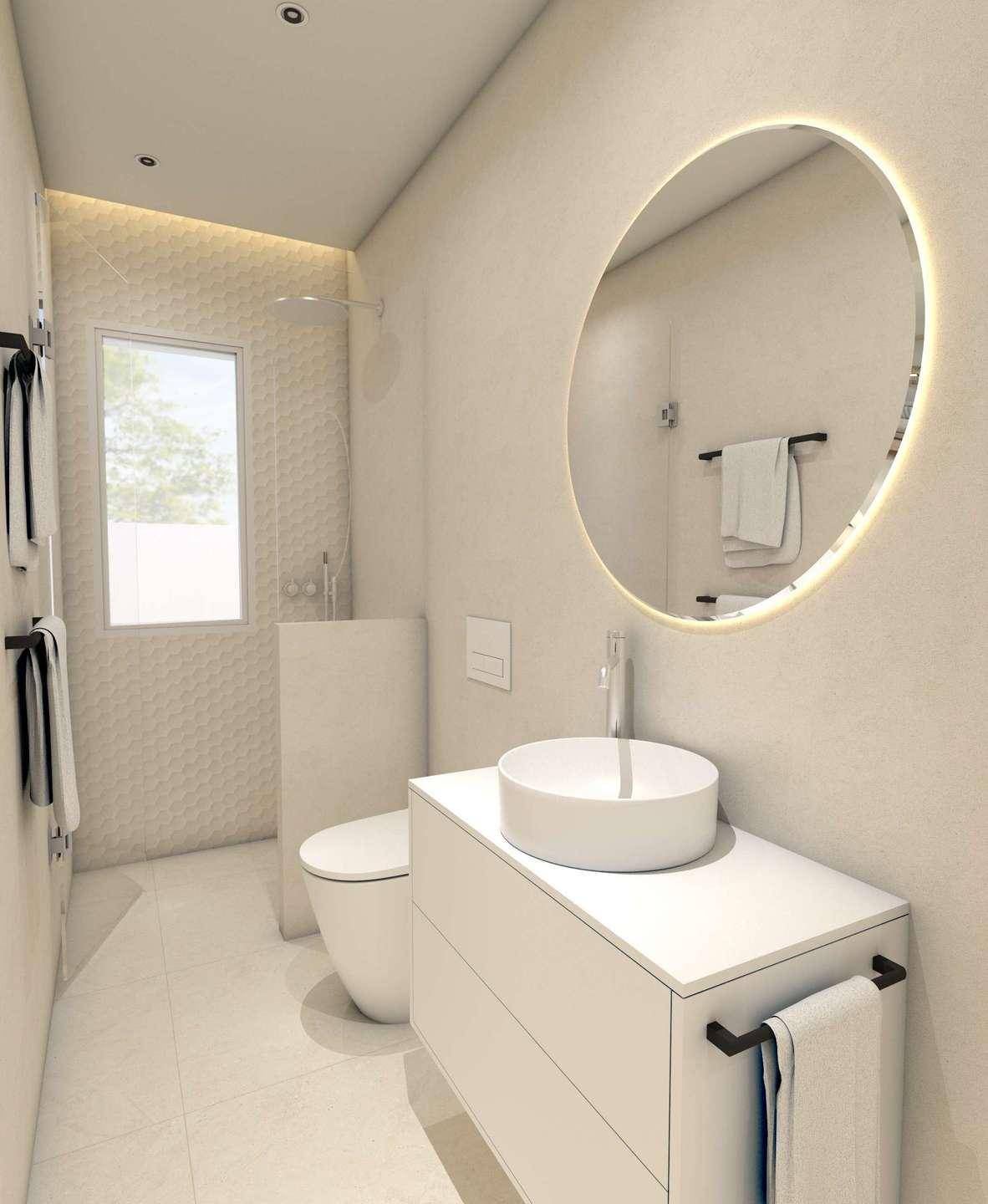 Modernes Badezimmer mit runder beleuchteter Spiegelfläche, weißem Waschbecken und begehbarer Dusche.