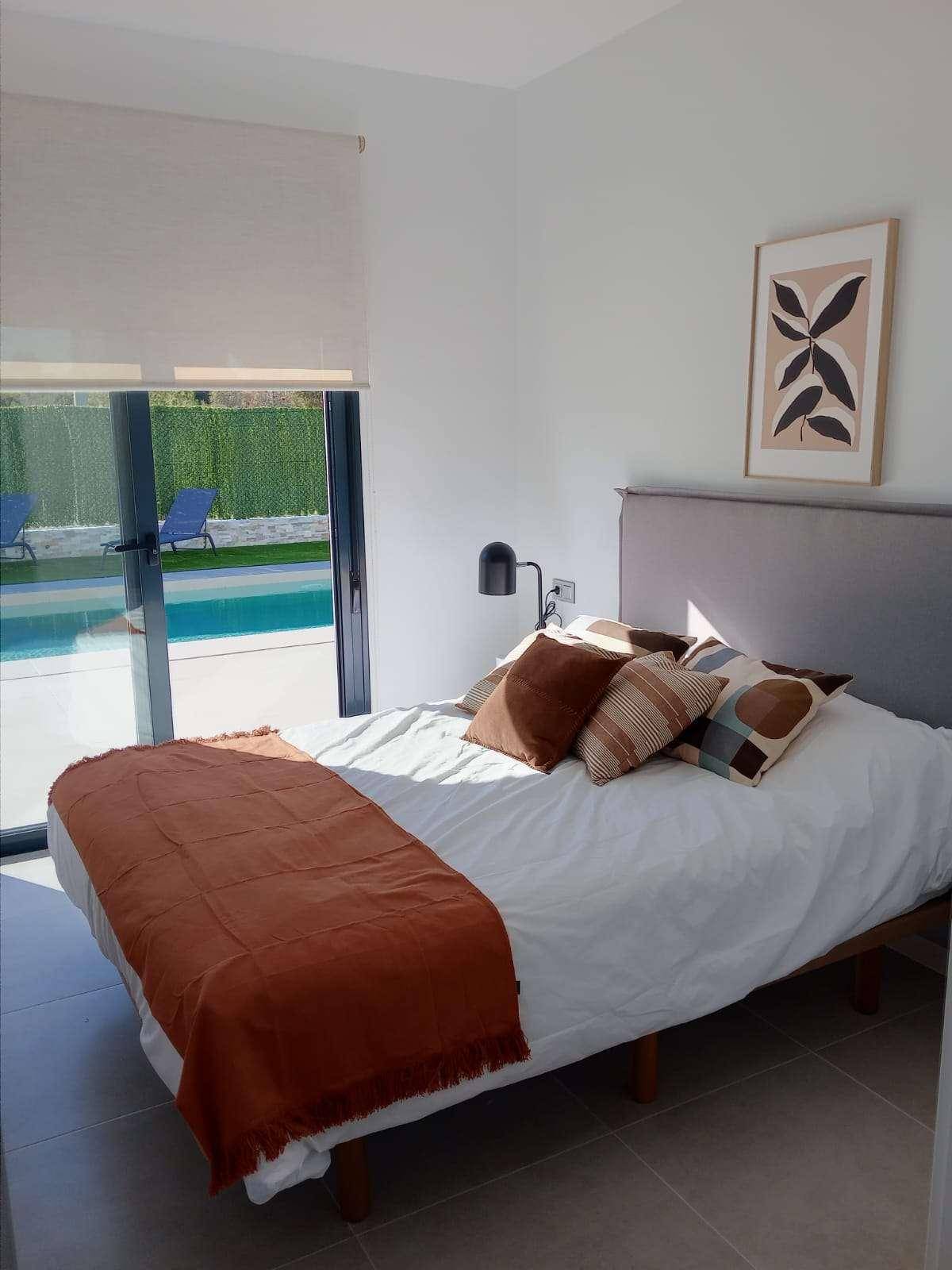 Helles Schlafzimmer mit modernem Dekor und Blick auf den Swimmingpool.