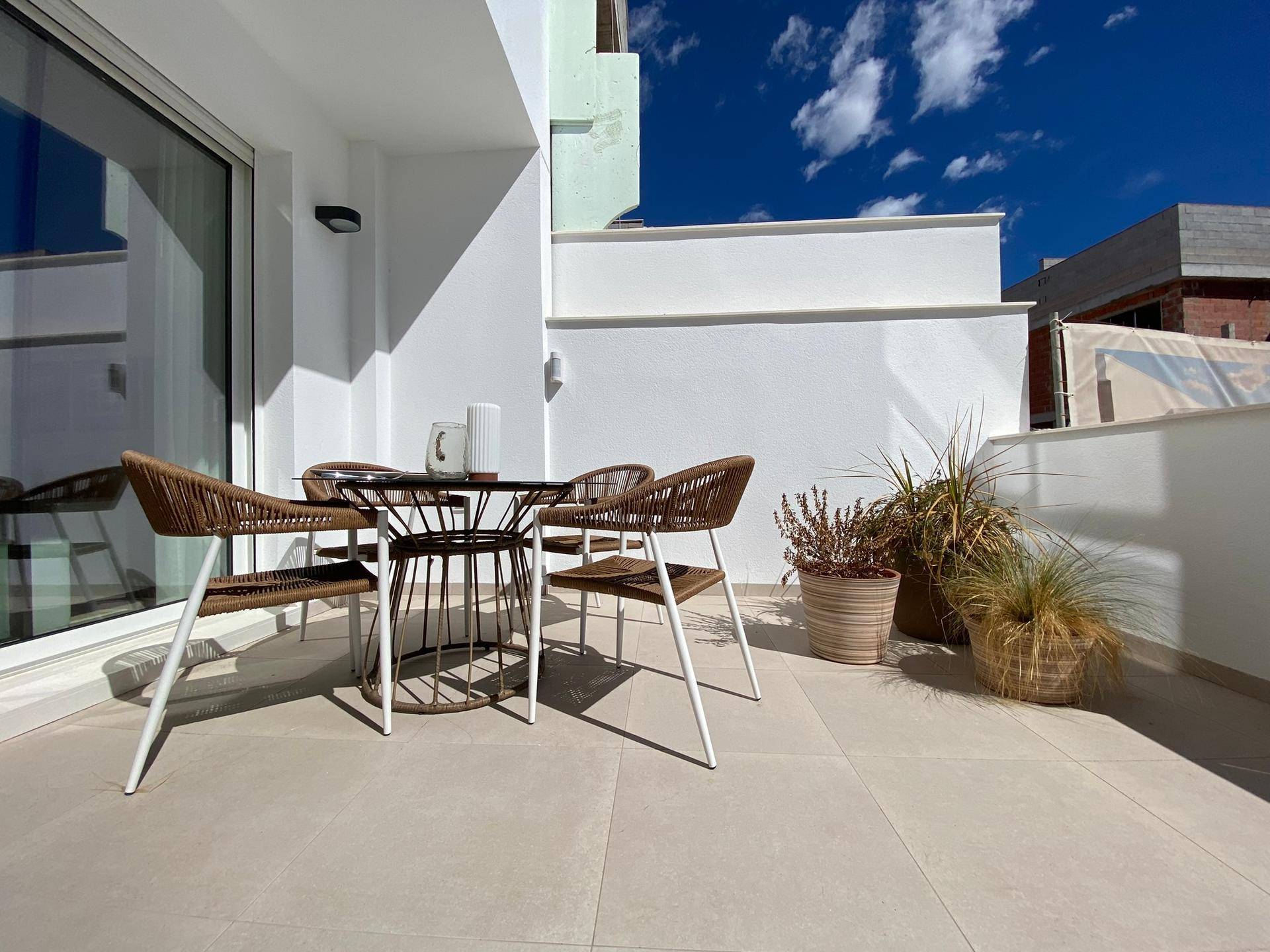 Möblierter Balkon mit Esstisch und Pflanzen, ideal für Mahlzeiten im Freien.