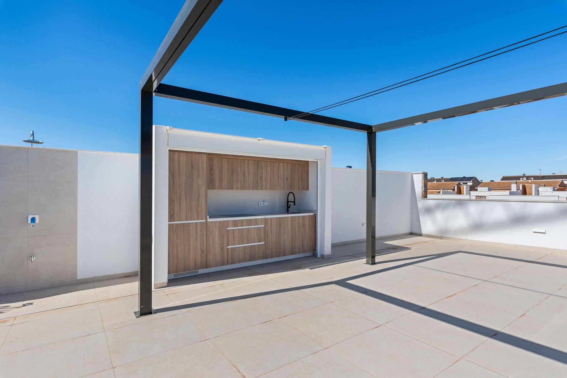Sonniger Dachbereich mit Pergola und integrierter Außenküche für gesellige Stunden.