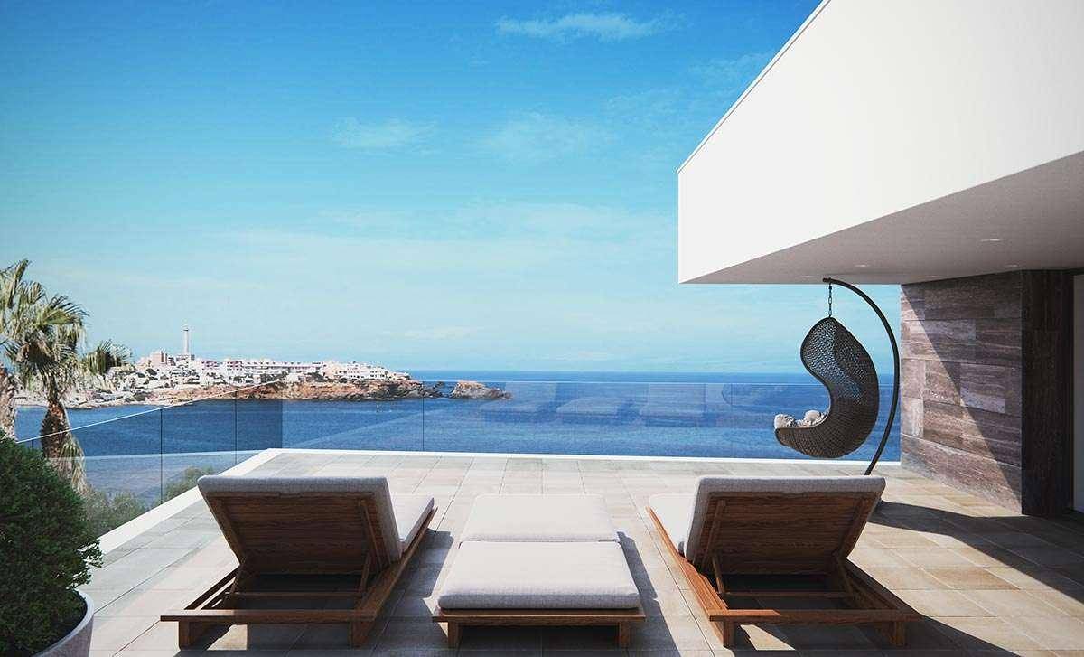 Weitläufige Dachterrasse mit atemberaubendem Meerblick, Sonnenliegen und Hängesessel für Entspannung.