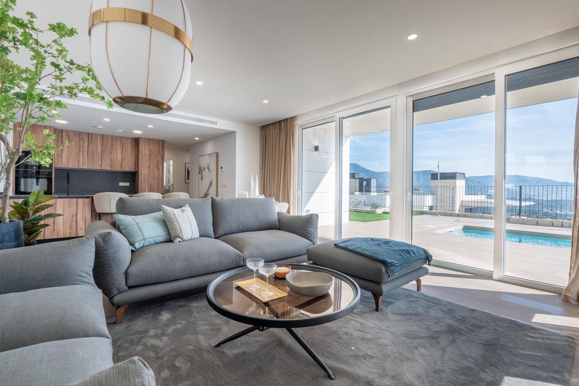 Helles Wohnzimmer mit bequemen Sofas, modernem Dekor und Blick auf den privaten Pool.