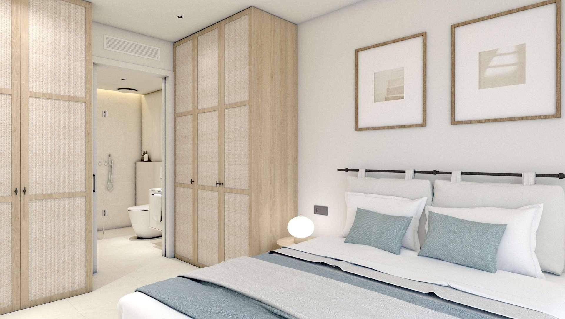 Schlafzimmer mit Doppelbett, Einbauschränken und direktem Zugang zum Badezimmer.