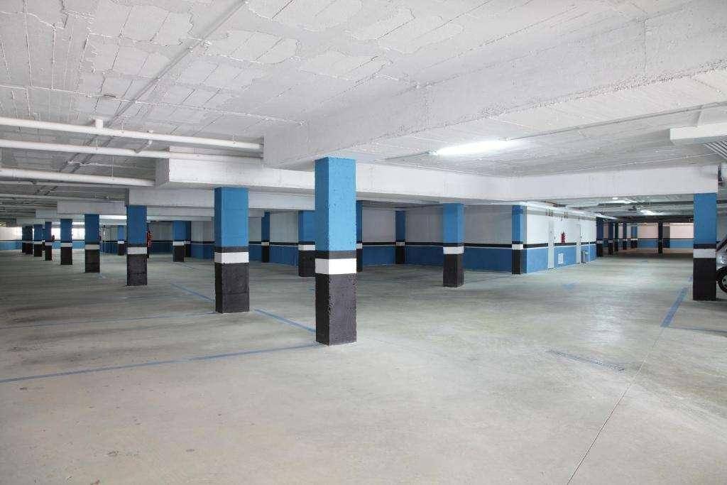 Geräumige Tiefgarage mit vielen Stellplätzen und blauen Markierungen auf dem Boden.