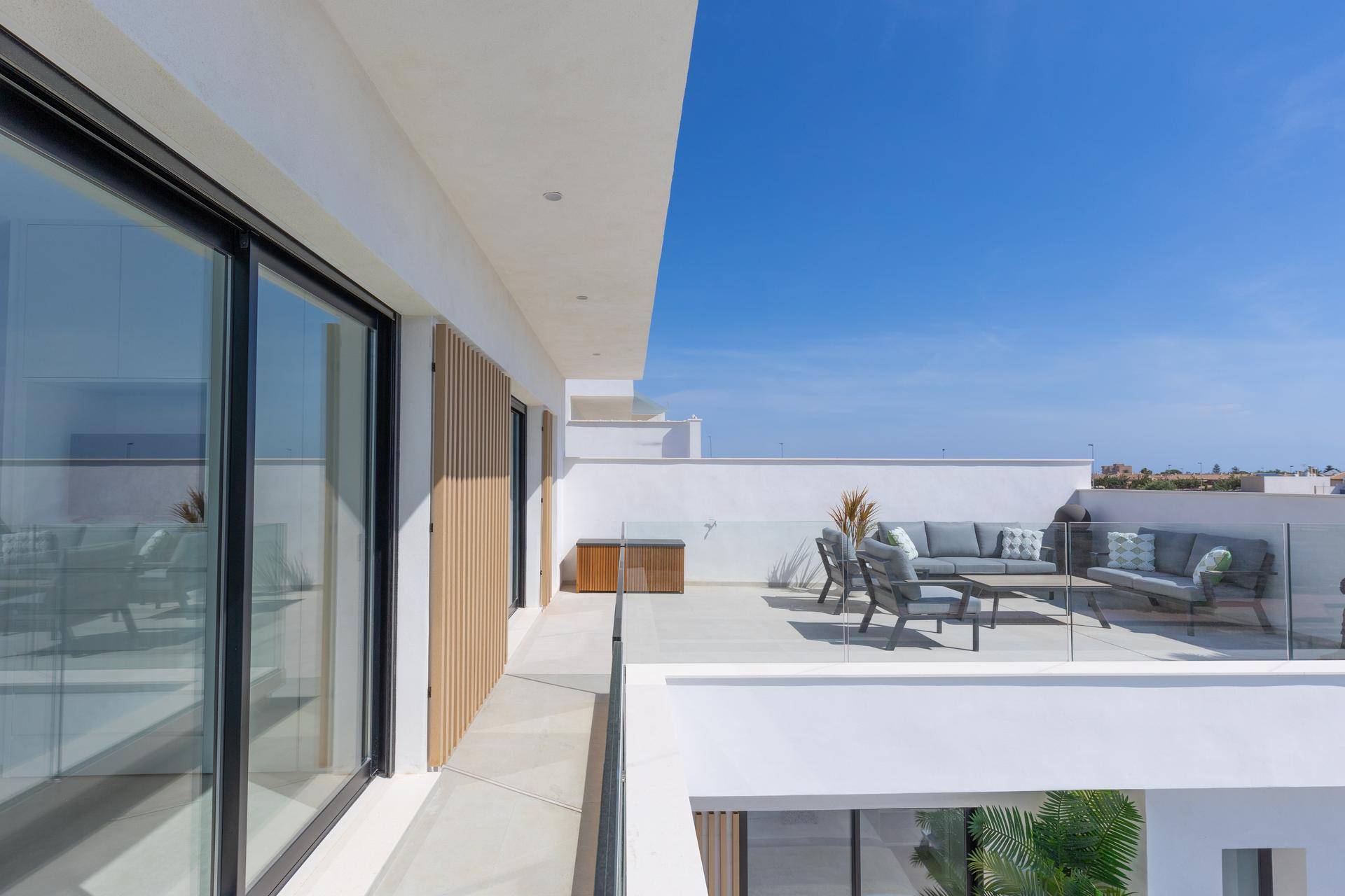 Moderner Balkon mit Glasgeländer und weitem Blick auf die Umgebung.