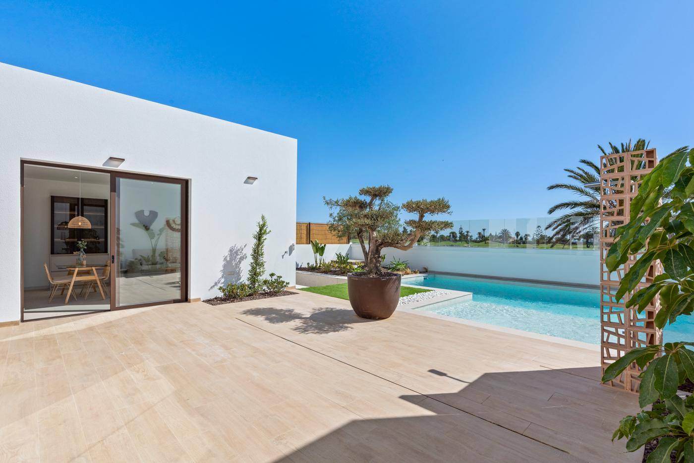 Geräumige Terrasse mit hellem Bodenbelag und Blick auf den Pool und die umliegende Landschaft.