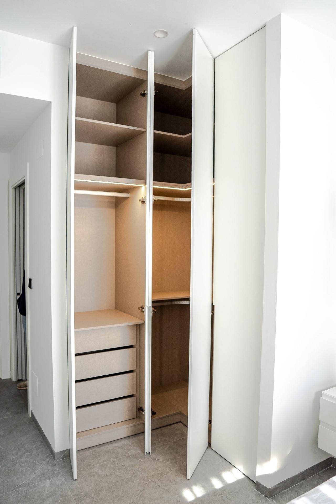 Geräumiger Einbauschrank mit offenen Türen, Regalen und Schubladen für optimale Organisation.
