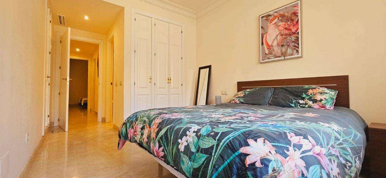 Schlafzimmer mit großem Bett, floraler Bettwäsche und Einbauschränken.