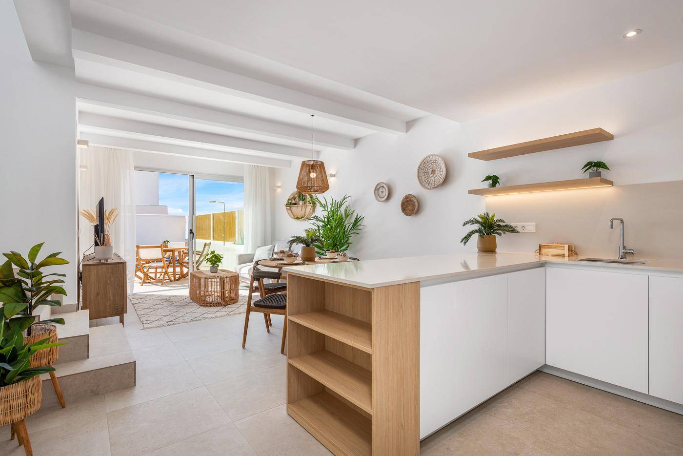 Offener Wohn-Essbereich mit integrierter Küche und Zugang zur Terrasse, modern eingerichtet.