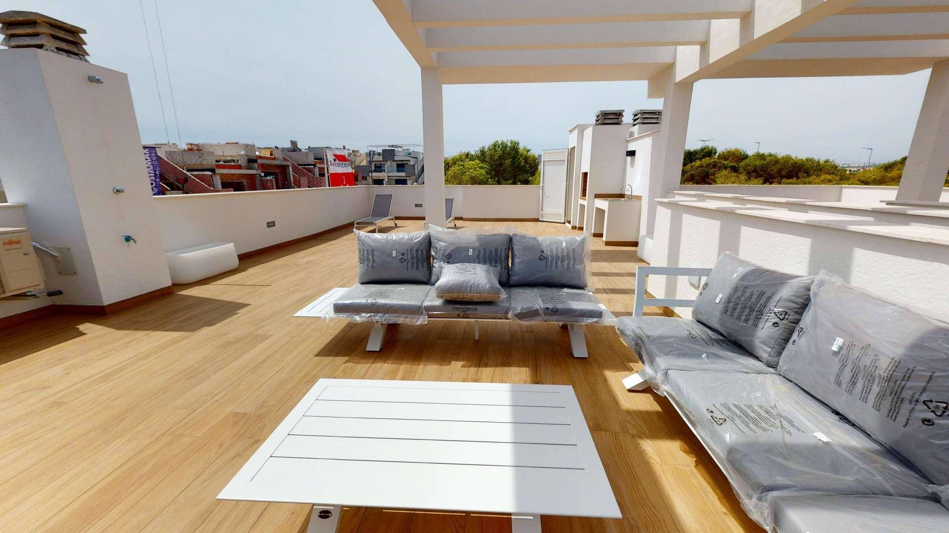 Weitläufige Dachterrasse mit Holzfußboden, bequemen Sitzmöbeln und Blick auf die Umgebung.