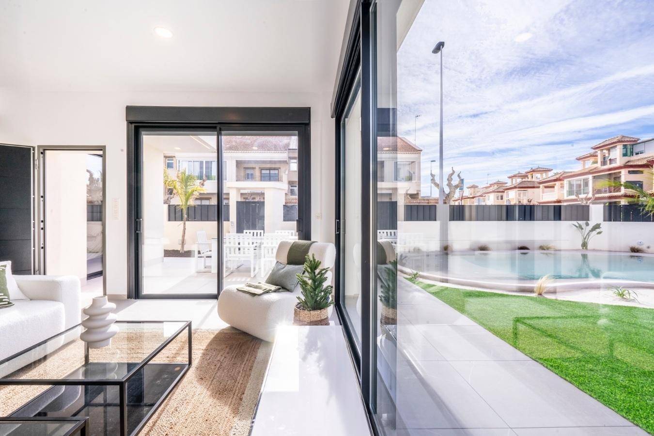 Geräumiges Wohnzimmer mit viel Tageslicht und direktem Zugang zum Garten mit privatem Poolbereich.