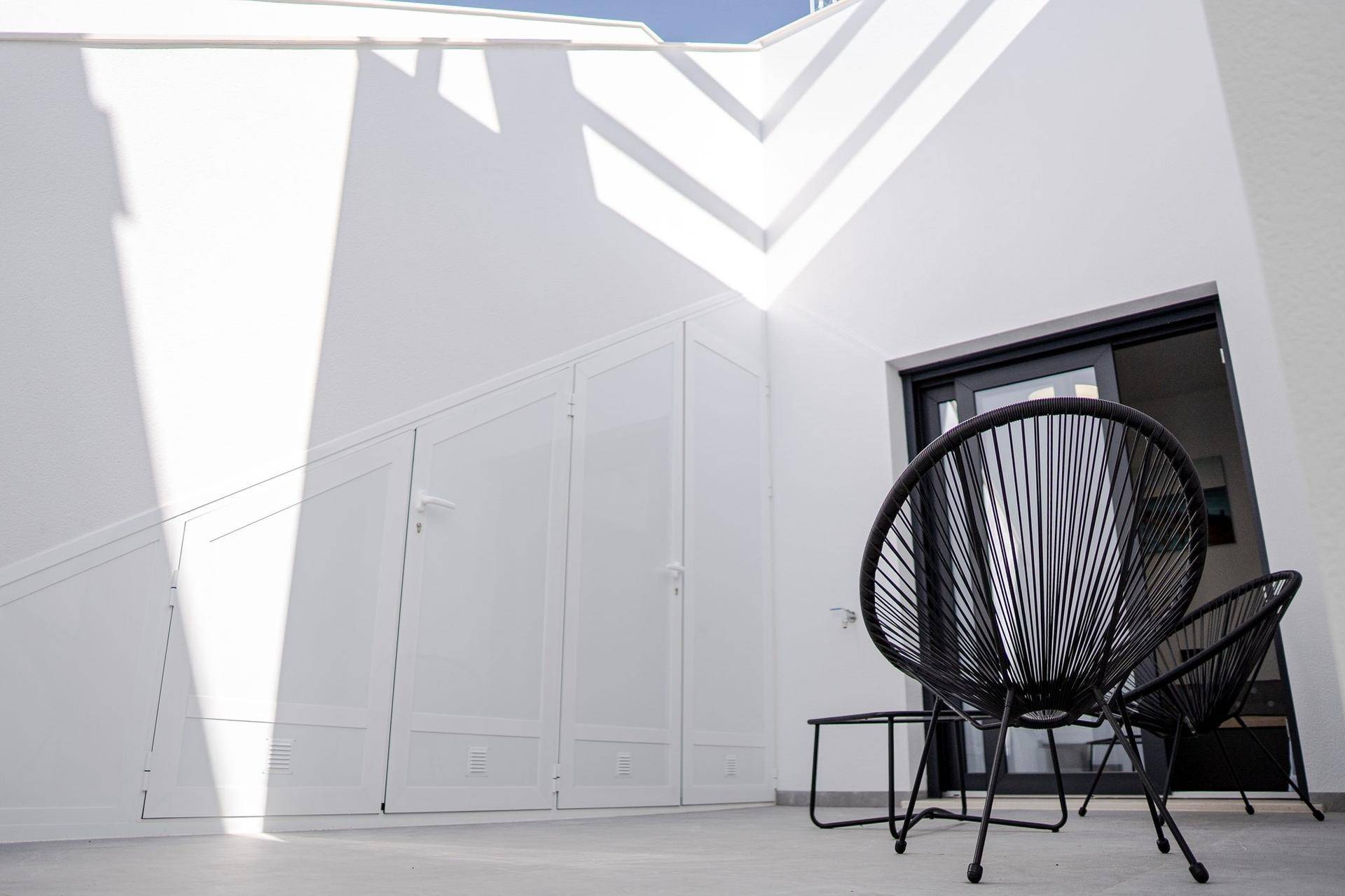 Sonniger Terrassenbereich mit integrierten Stauschränken und modernen Outdoor-Möbeln für Entspannung.