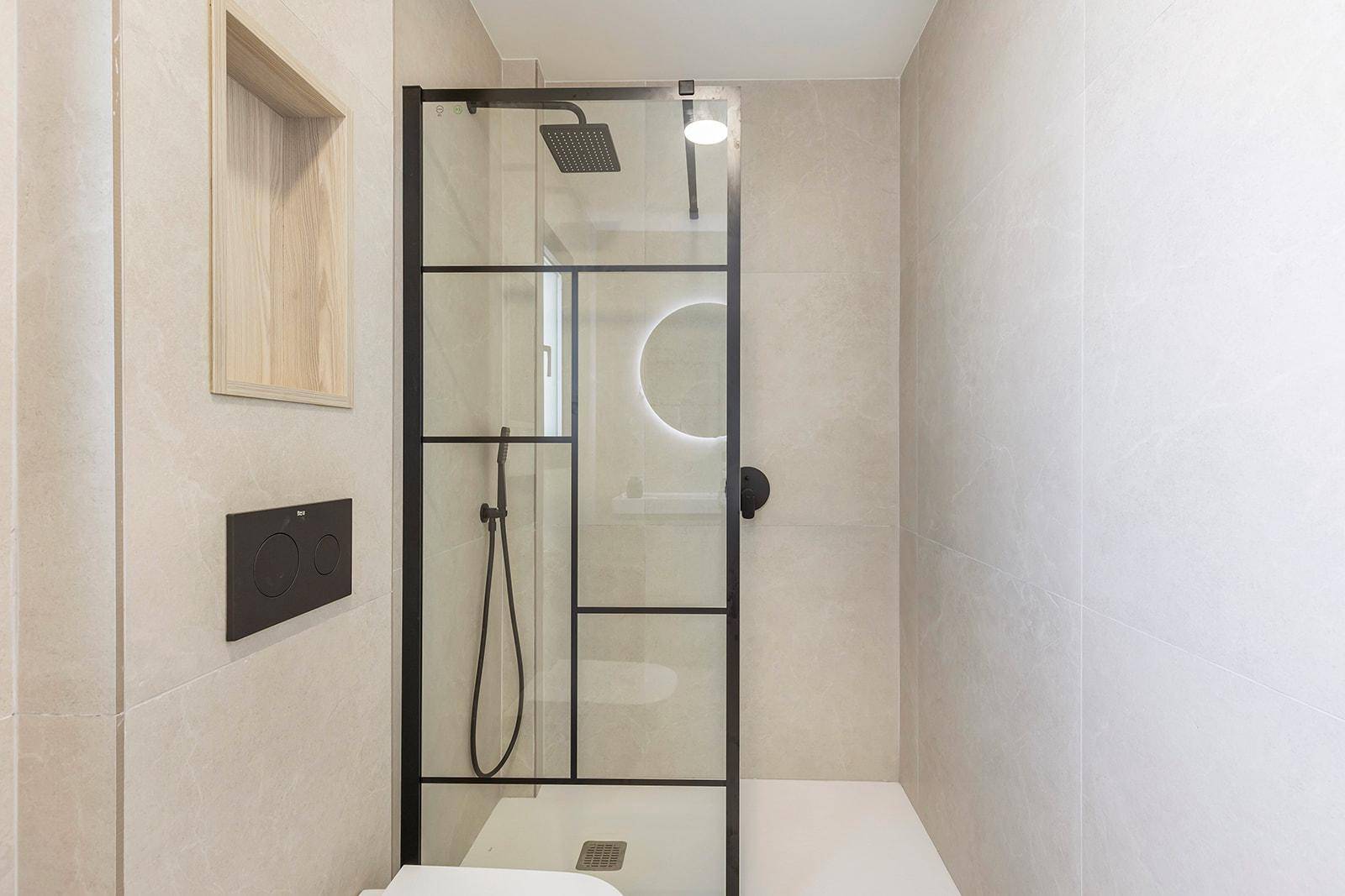 Modernes Badezimmer mit begehbarer Dusche, minimalistischem Design und indirekter Beleuchtung.