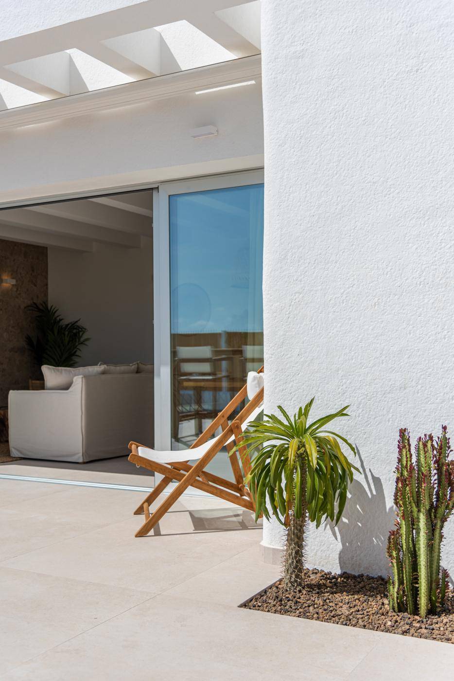 Terrassenbereich mit Liegestuhl und Kakteen, angrenzend an den Innenbereich.