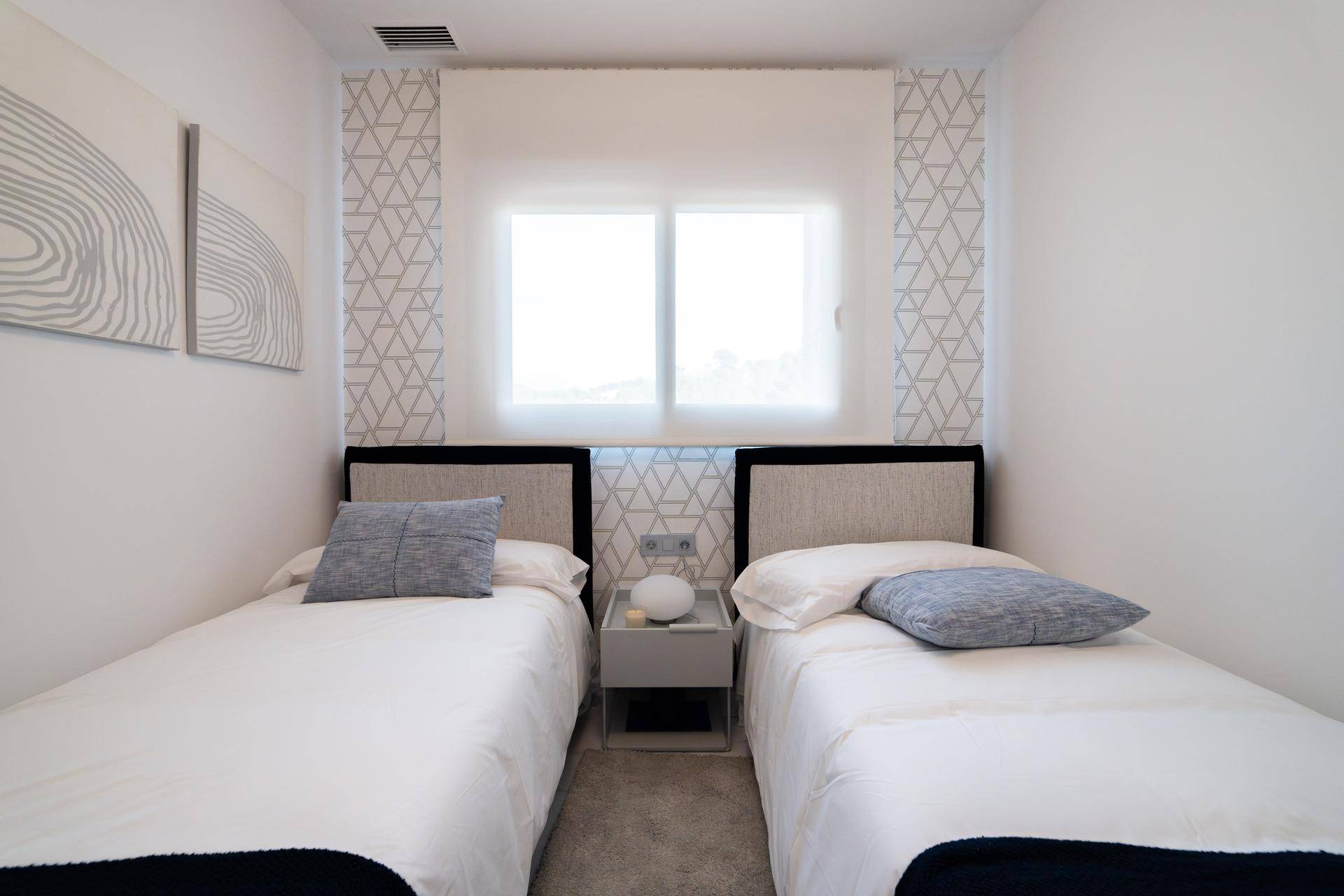 Helles Schlafzimmer mit zwei Einzelbetten, modernem Design und Fenster.