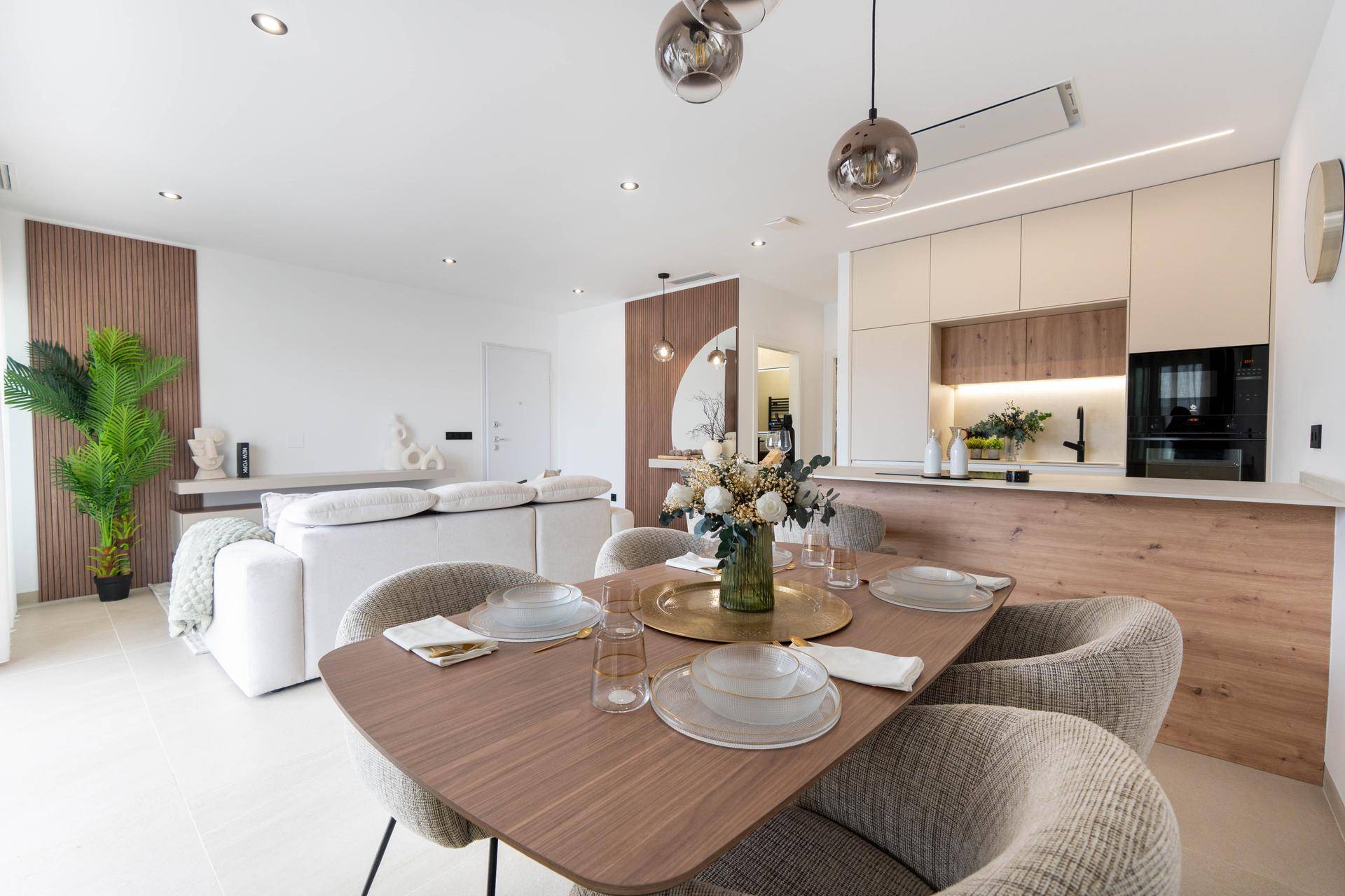 Elegantes Esszimmer mit Holztisch, bequemen Stühlen und Blick auf die offene Küche.