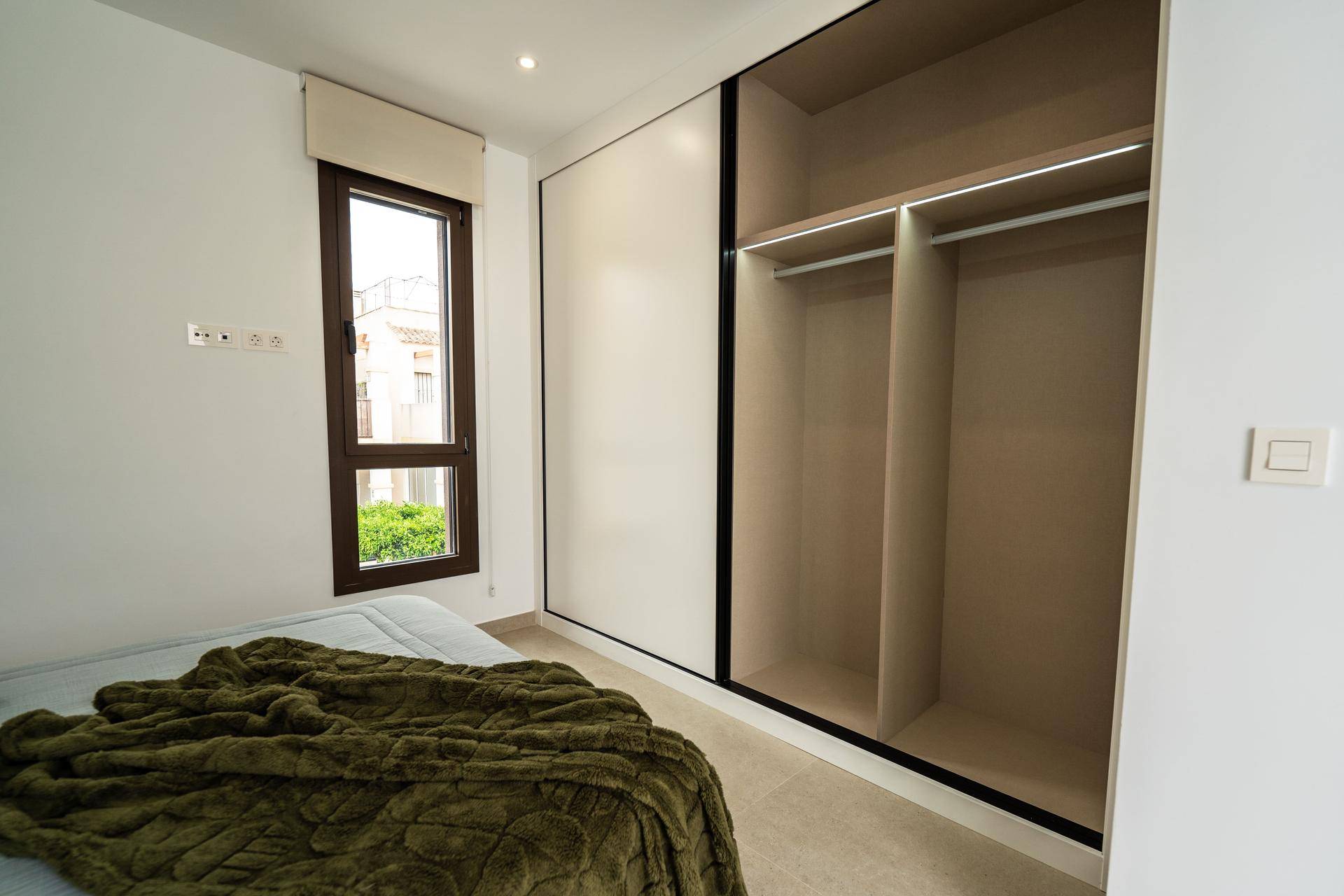 Helles Schlafzimmer mit bequemen Bett und geräumigen Einbauschränken, bietet viel Stauraum.