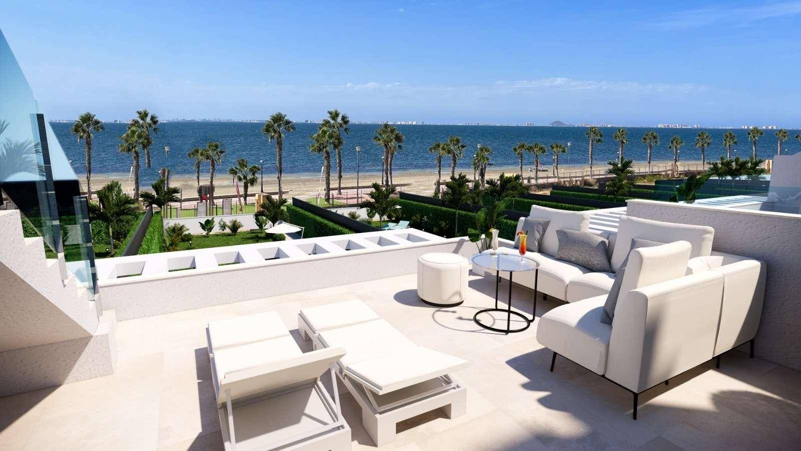 Geräumige Dachterrasse mit modernen Lounge-Möbeln und atemberaubendem Meerblick über Palmen.