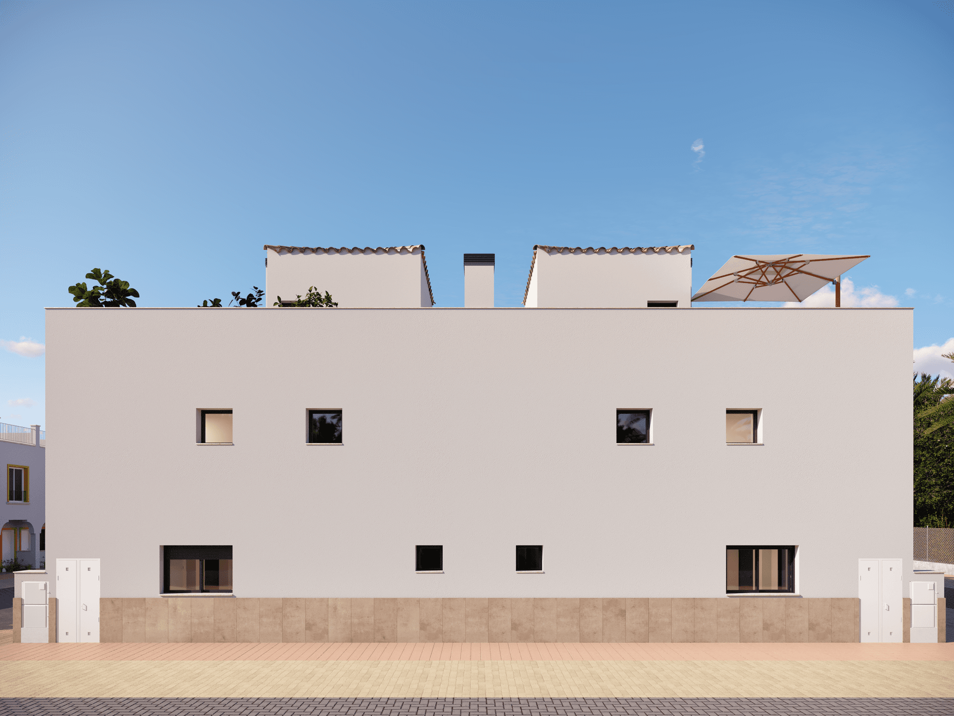 Seitenansicht eines Reihenhauses mit schlichter weißer Fassade und kleinen Fenstern.