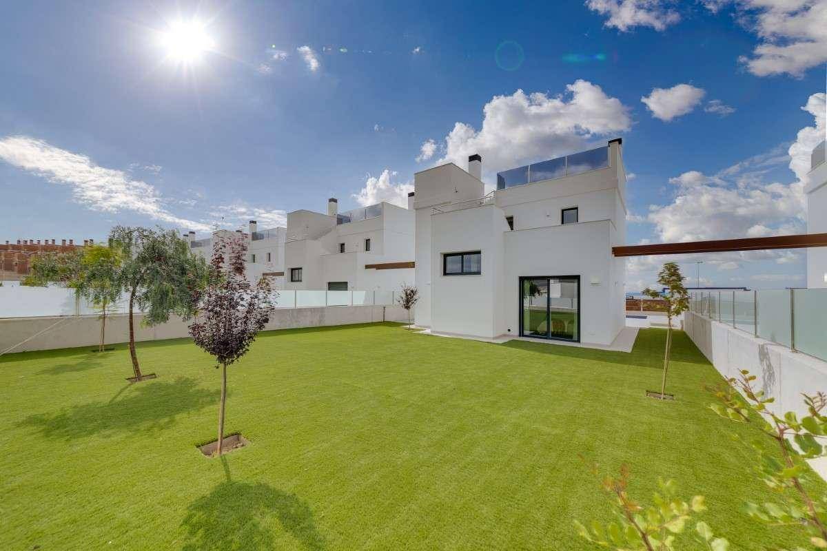 Großer, gepflegter Garten mit Rasenfläche und jungen Bäumen neben der modernen Villa.