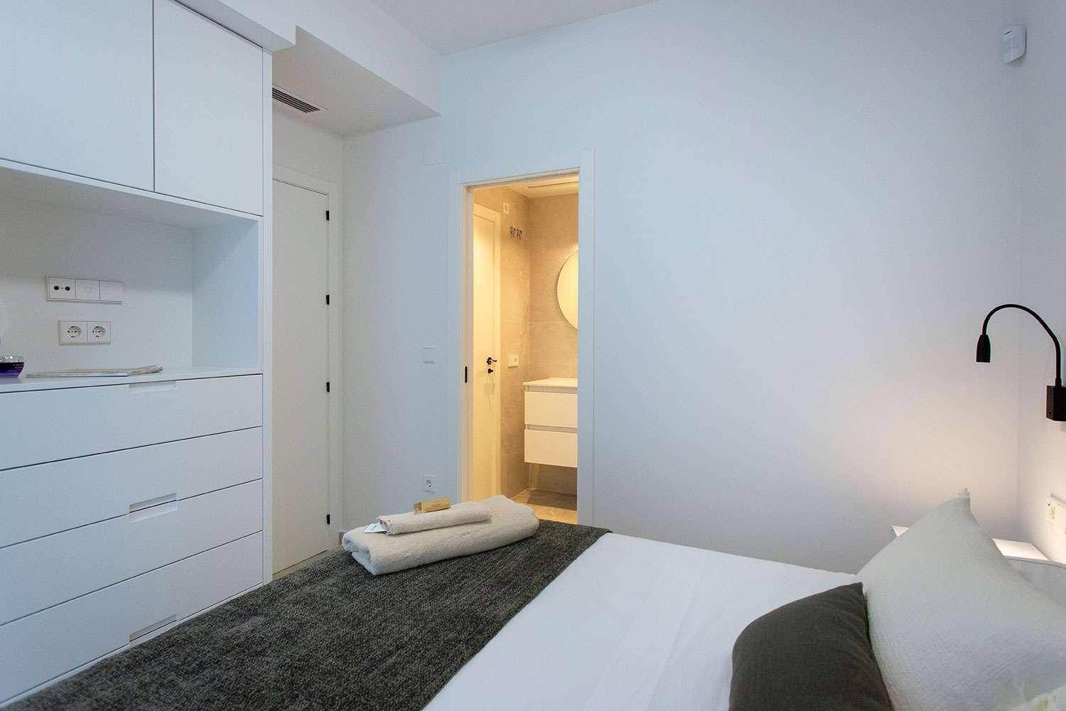 Schlafzimmer mit integrierten Schränken und Blick auf das moderne Badezimmer, sehr praktisch.