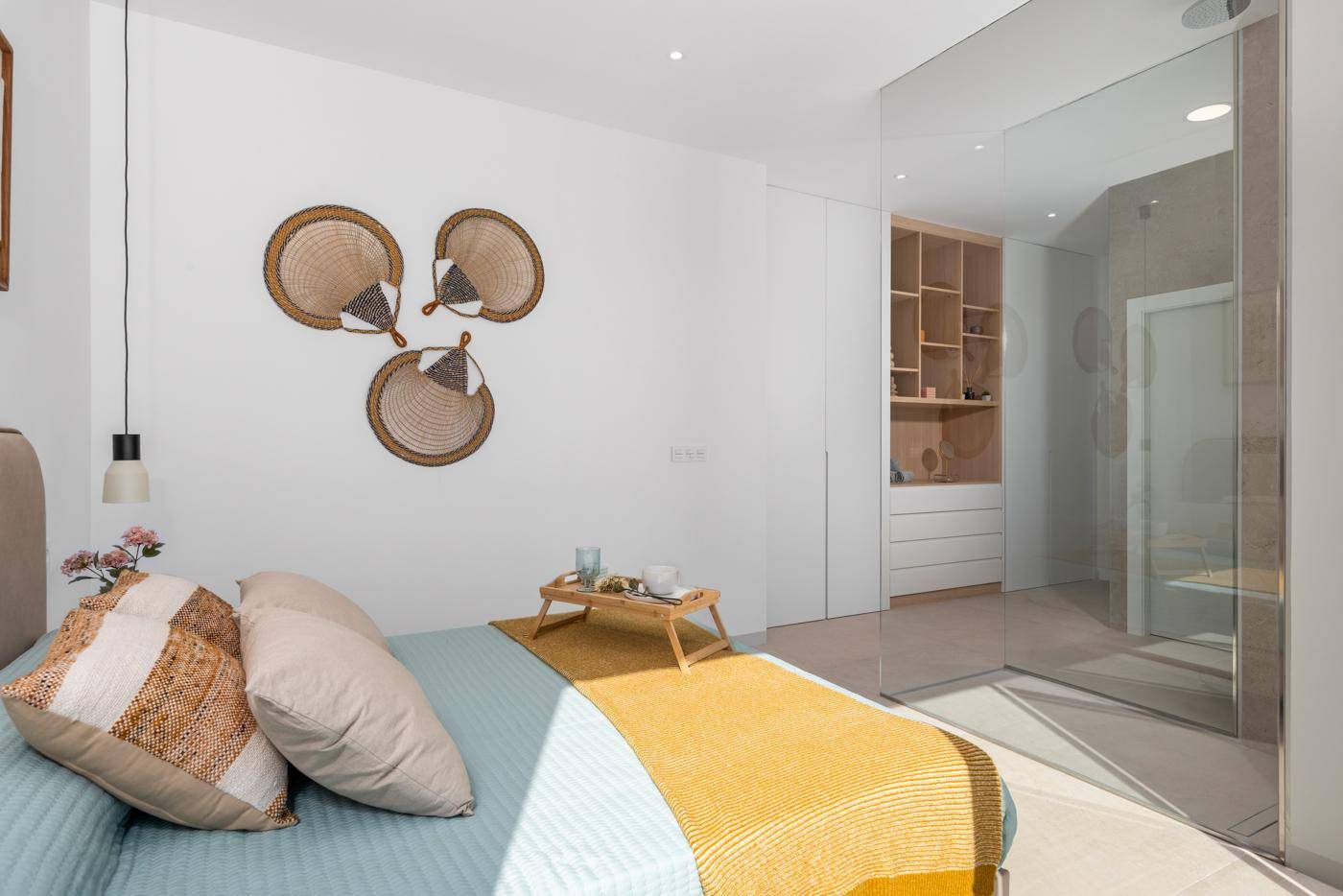 Modernes Schlafzimmer mit stilvoller Dekoration und offenem Zugang zum Badbereich.