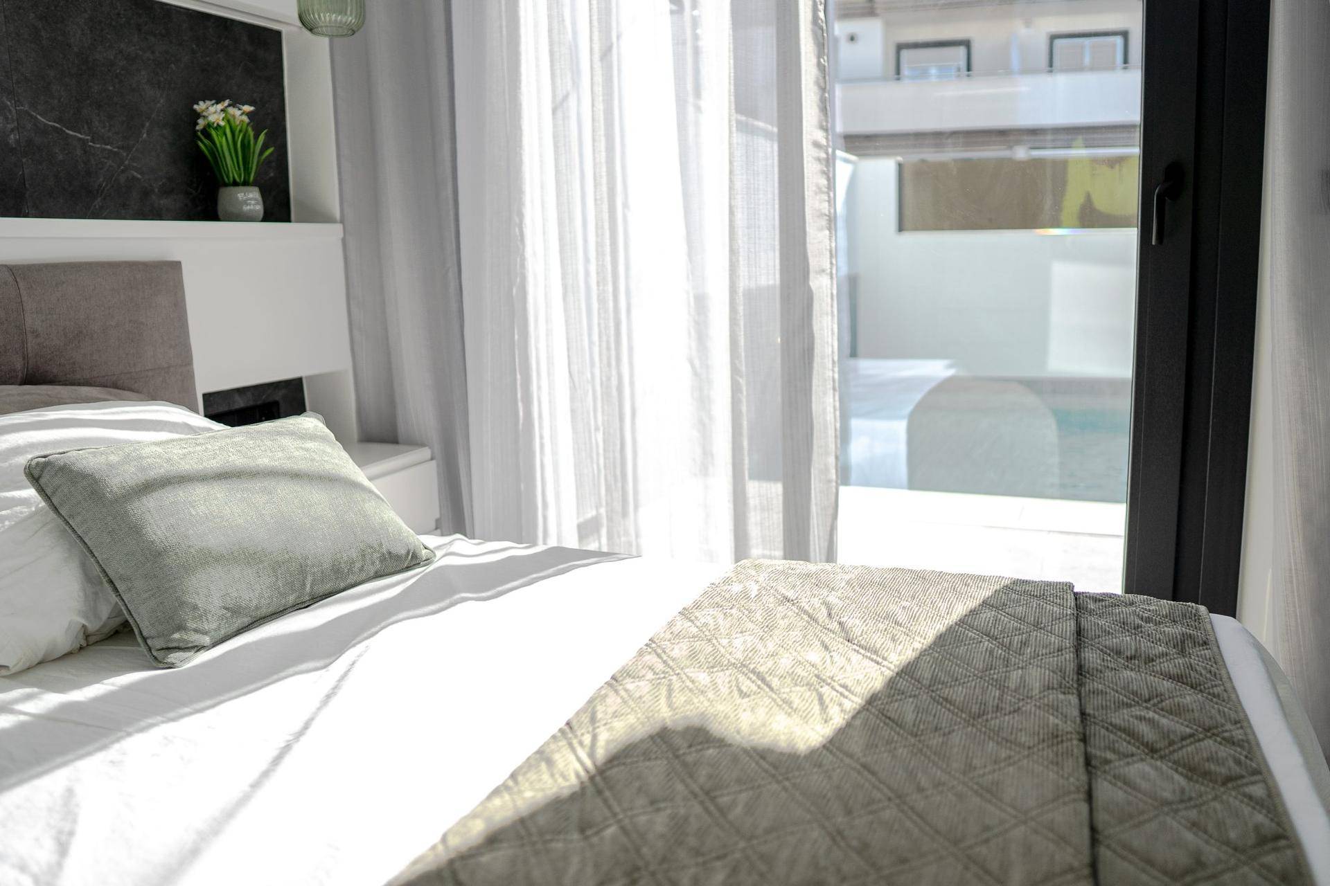 Sonniges Schlafzimmer mit bequemem Bett und direktem Zugang zu einem privaten Außenbereich.