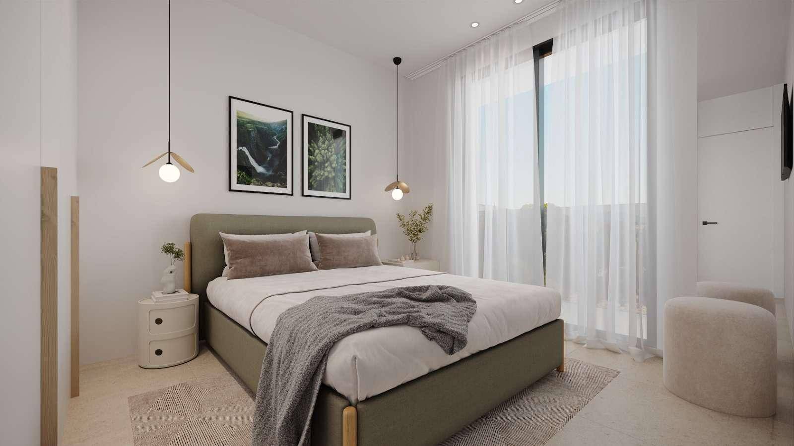 Helles Schlafzimmer mit modernem Bett, Nachttischen und einem großen Fenster mit Blick nach draußen.