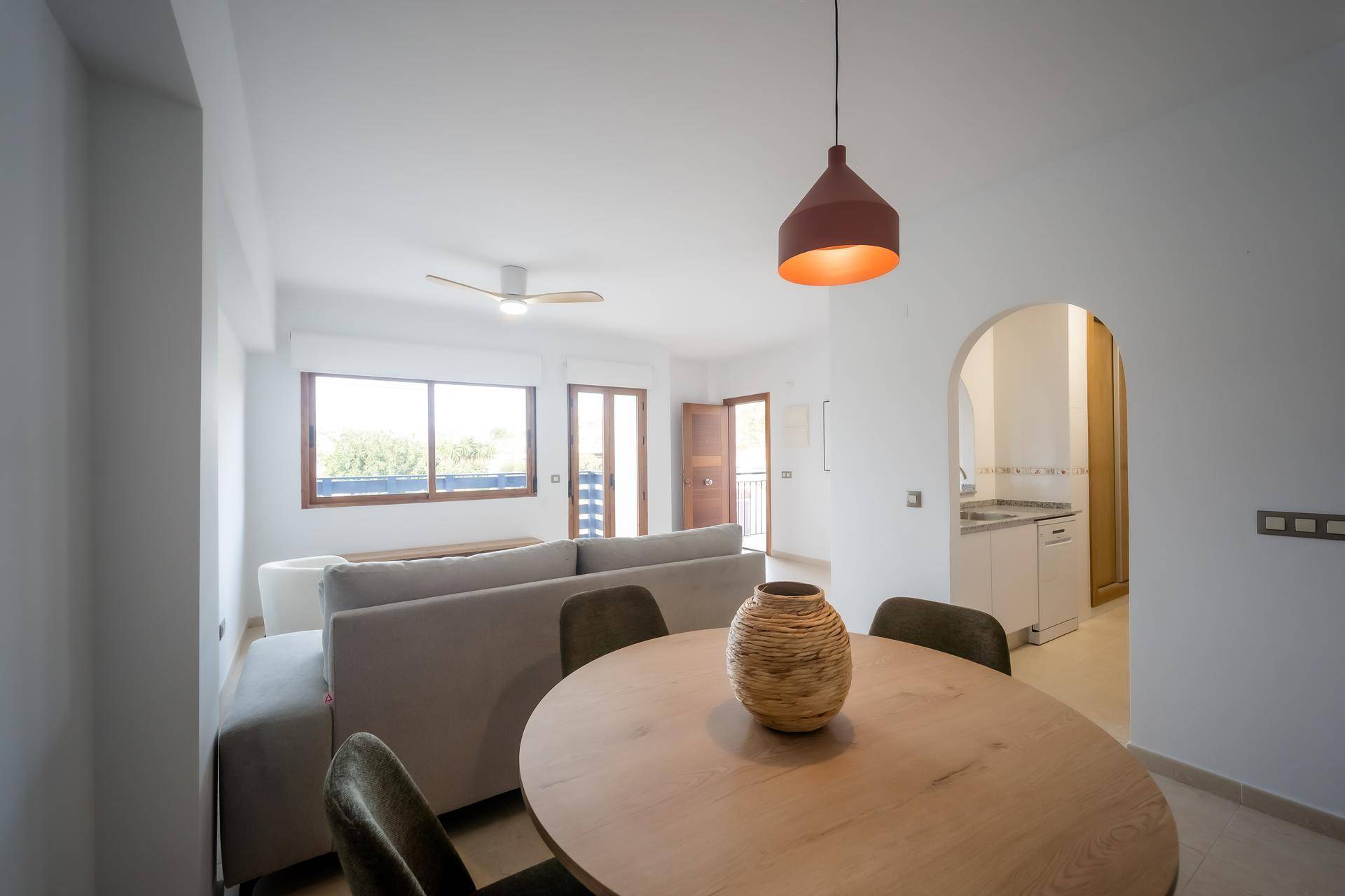 Offener Wohn- und Essbereich mit modernem Esstisch, Sofa und Blick zur Küche.
