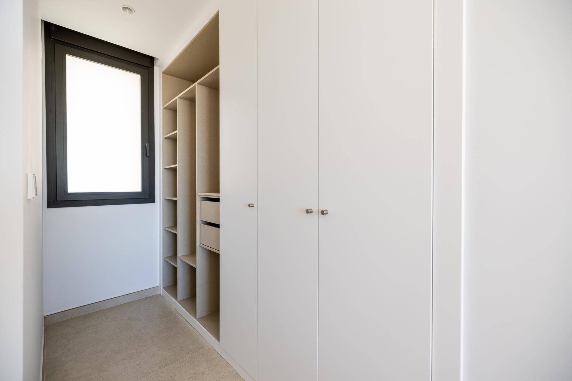 Praktischer begehbarer Kleiderschrank mit integrierten Regalen und viel Stauraum.