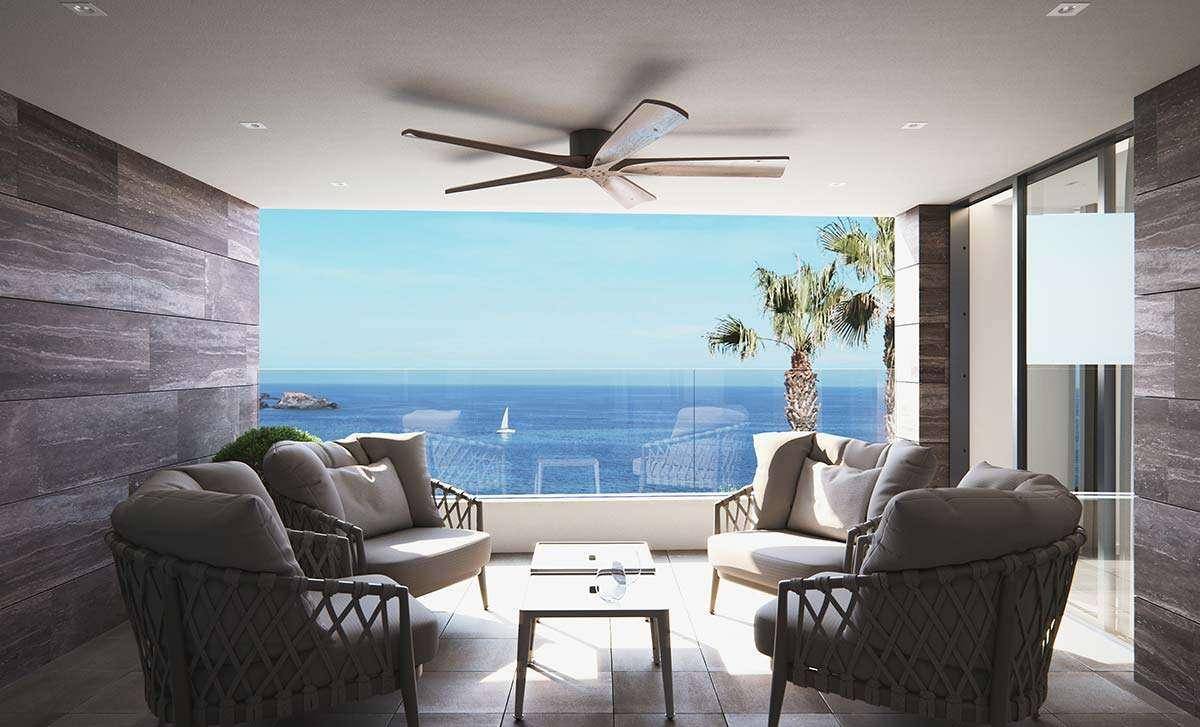 Gemütliche Loggia mit Meerblick, bequemen Loungemöbeln und Deckenventilator für angenehme Stunden.