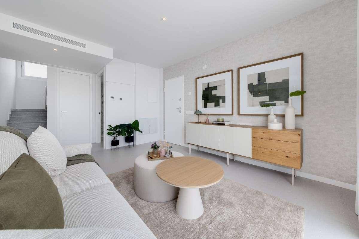 Gemütliches Wohnzimmer mit moderner Einrichtung, Kunstwerken und Zugang zu einer Treppe.