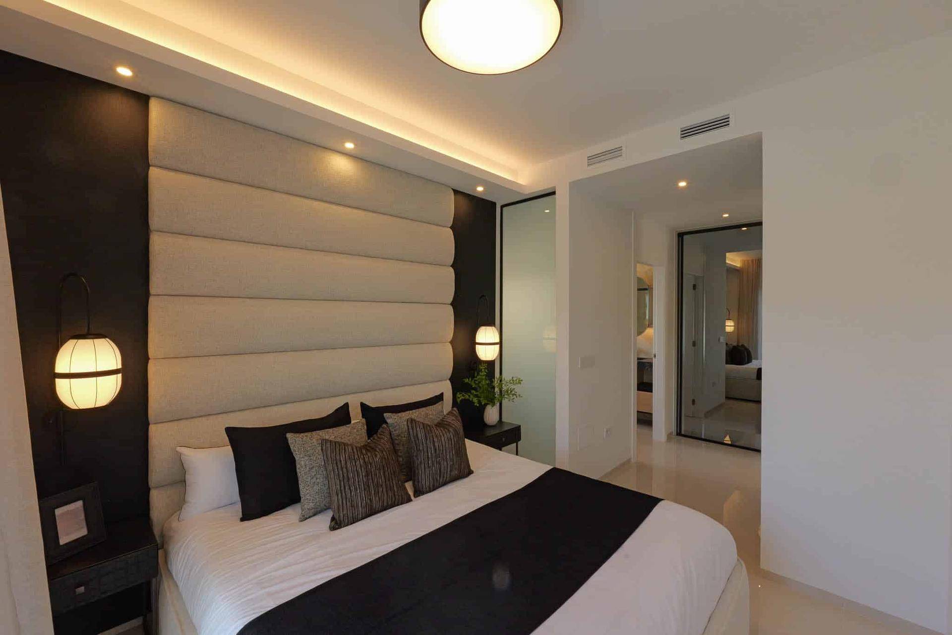 Helles Schlafzimmer mit gepolstertem Kopfteil und Blick auf den Pool, bietet eine entspannende Umgebung.