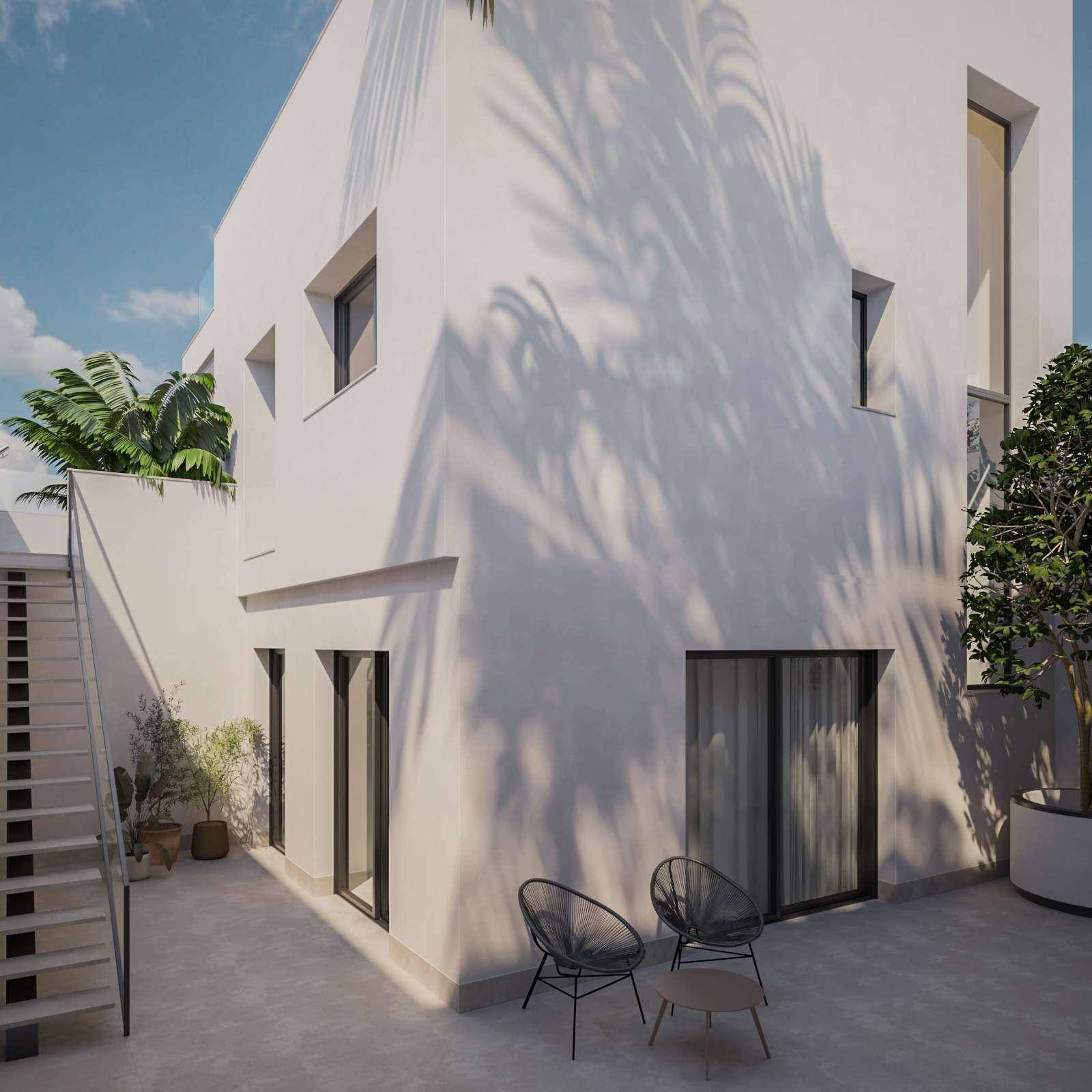 Seitliche Ansicht der modernen Villa mit Außentreppe und kleinem, schattigen Terrassenbereich.