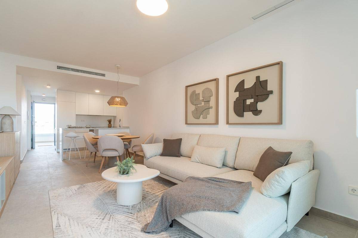 Offener Wohn-Essbereich mit Sofa, Esstisch und integrierter moderner Küche.