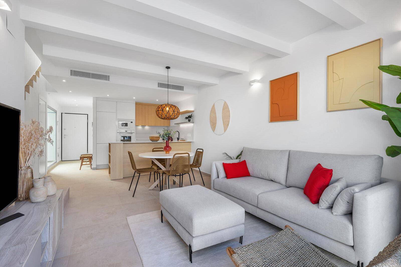Geräumiger Wohn- und Essbereich mit offener Küche, bequemer Couch und modernem Interieur.