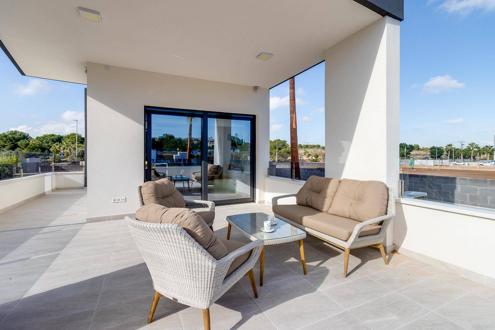 Sonnige Terrasse mit bequemen Outdoor-Möbeln und Blick auf die Umgebung.