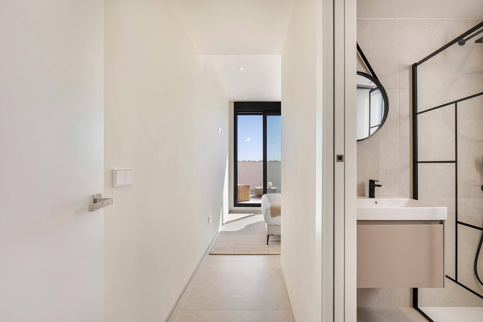 Heller Flur mit Zugang zu Schlafzimmer und Badezimmer, mit Blick auf die Terrasse.