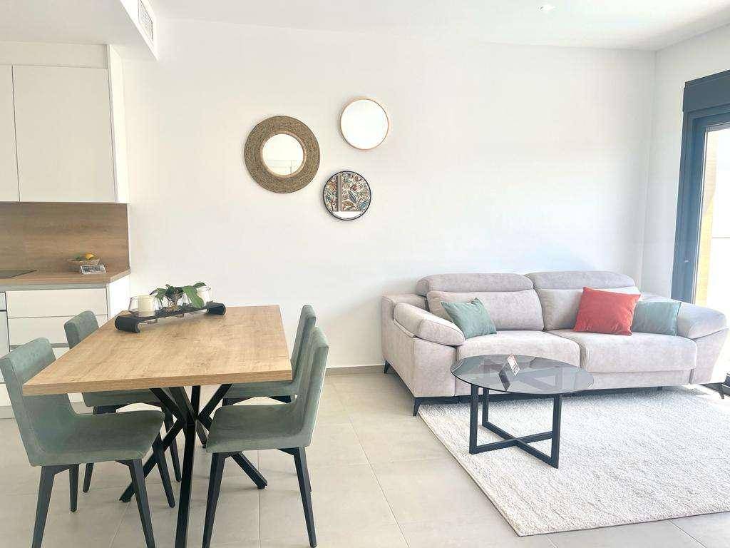 Moderner Wohn- und Essbereich mit offener Küche, hellem Sofa und stilvoller Dekoration.