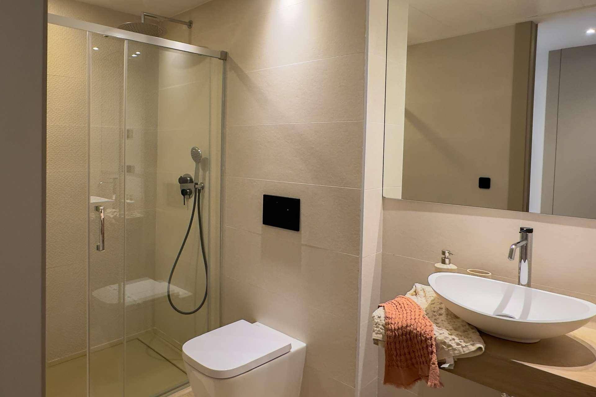 Modernes Badezimmer mit begehbarer Dusche, wandhängendem WC und elegantem Waschbecken.
