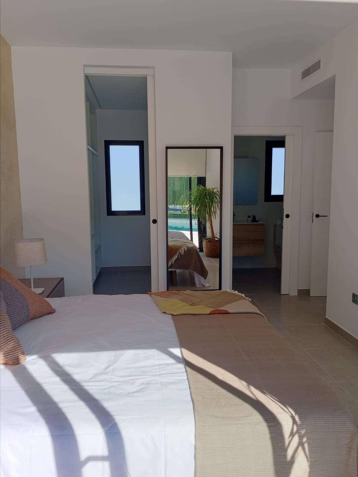 Schlafzimmer mit Zugang zu einem begehbaren Kleiderschrank und einem Badezimmer.
