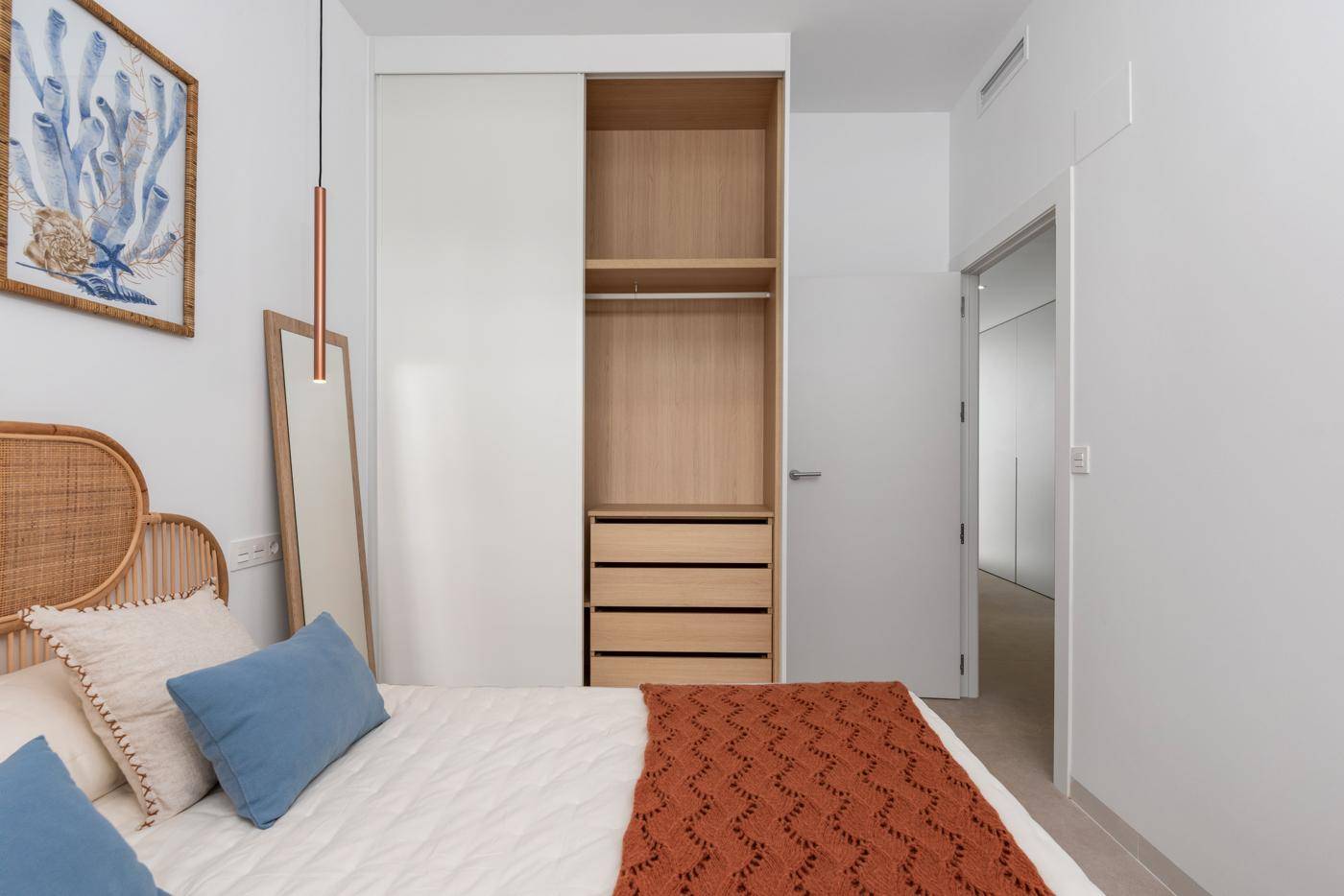 Schlafzimmer mit offenen Einbauschränken, die viel Stauraum bieten.