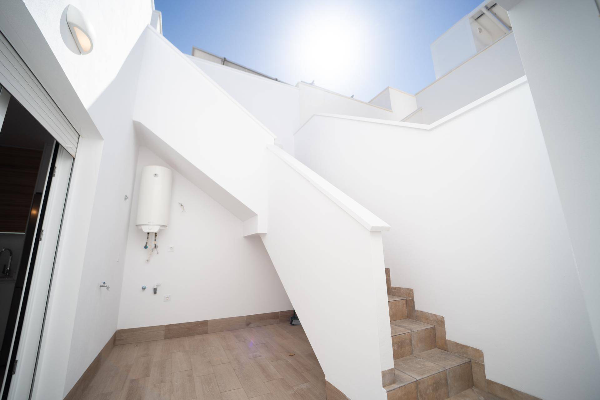 Heller Außenbereich mit Treppe, die zu einer oberen Terrasse oder Dachterrasse führt.